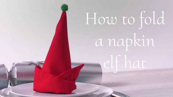 A cute elf hat napkin fold, sitting upright on a plate