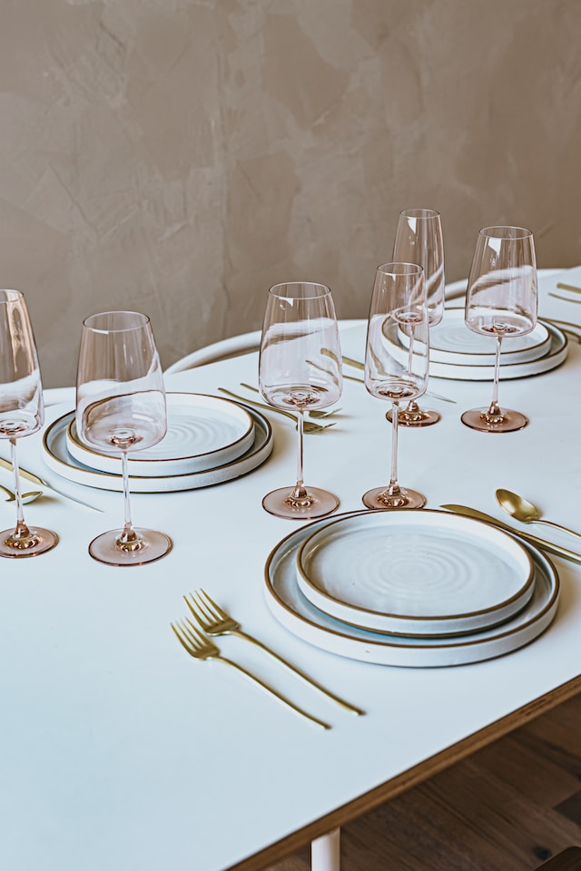 Table setting with white tablecloth, layered plates and cutlery