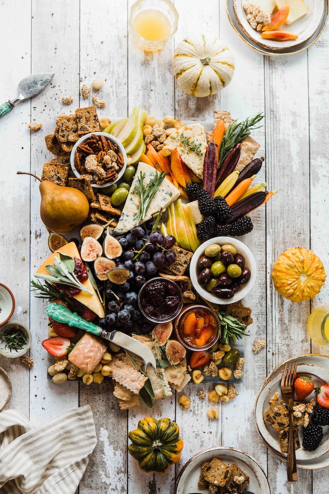 table centre piece of cheese, figs, olives, crackers, vegetables